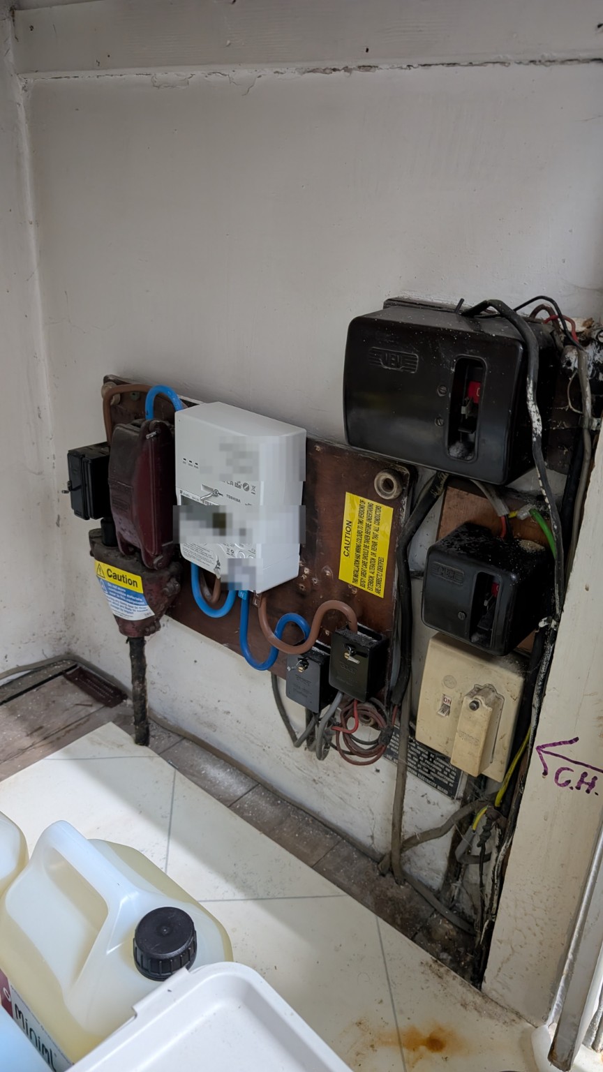Outdated service cut-out and consumer unit under the stairs
